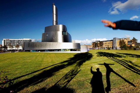 Modern Northern Lights Cathedral in Alta with long shadows on the meadow, Alta, Finnmark, Norway