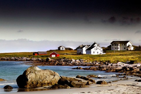 Small settlement with white houses on the beach, surrounded by rocks and sea, Ramberg, Flakstadøy,
