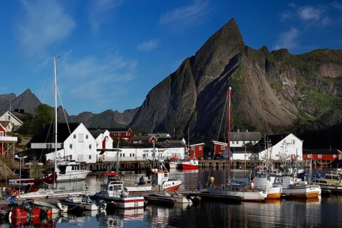 Sakrisøy harbour with boats, surrounded by the distinctive Lofoten mountains, Sakrisøy, Moskenesøy,