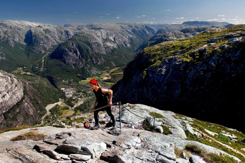 Hikers climbing Mount Kjerag with breathtaking mountain scenery in the background, Lysefjord,