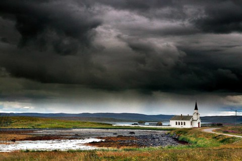 Small church in Nesseby under thick, dramatic clouds in the sky, Nesseby, Finnmark, Norway