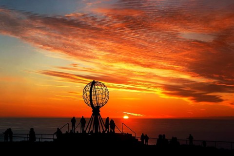 Sunset on the North Cape with colorful clouds and silhouettes in front of the globe, North Cape,