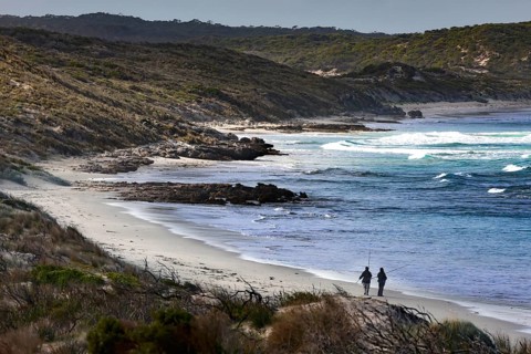 Two people stroll along the quiet beach at Vivonne Bay, Vivonne Bay, Kangaroo Island, Australia