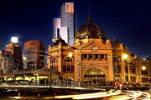 Flinders Street Station at night with magnificent lighting against an urban backdrop, Melbourne,
