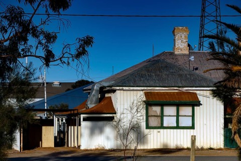 Single-family house in Marree with surrounding vegetation and blue sky, Marree, South Australia,
