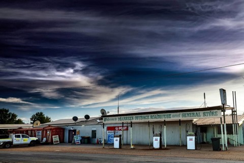 Abandoned gas station and storefront in Marree under dramatic sky, Marree, South Australia,