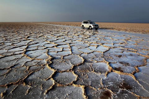 Landcruiser stands in an extensive salt desert with distinctive cracks, Dallol, Asale, Ethiopia