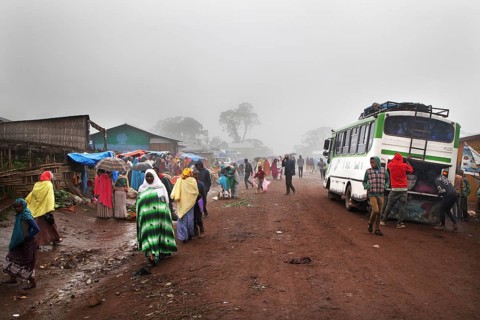 Different people and a bus on a foggy road in Rira, Rira, Bale Mountains, Ethiopia