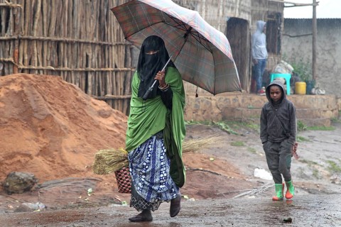 Woman and child under umbrella during rain in Rira, Bale Mountains, Rira, Bale Mountains, Ethiopia