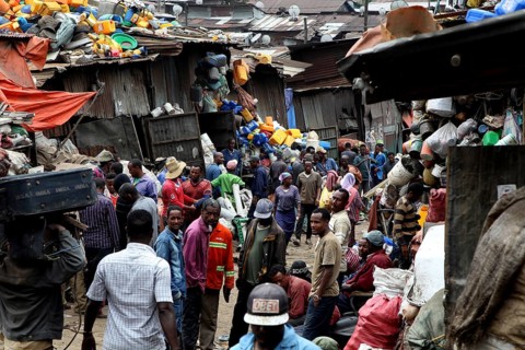 Large crowds of people on the busy Mercato in Addis Ababa, surrounded by colorful fabrics, Addis