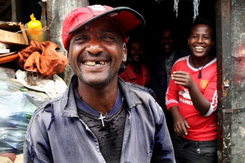 Happy people laugh in front of a shop in the Mercato of Addis Ababa, Addis Ababa, Ethiopia