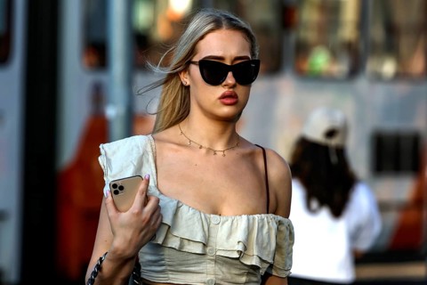 Woman wearing elegant dress wearing sunglasses strolling through a street in Tallinn, Tallinn,
