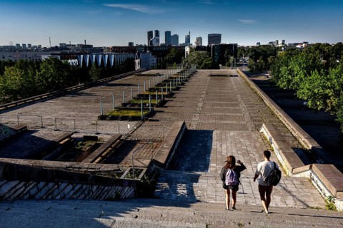 Two walkers on the abandoned platform of the city hall (Linnahall) with skyline view, Tallinn,