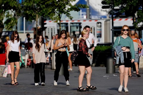 People stroll through the sunny old town, dressed in casual summer clothes, Tallinn, Harju, Estonia