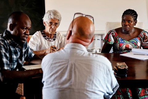 Several people in intensive discussion around a table in a closed room, Korhogo, Côte d'Ivoire