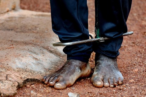 Cuffed feet in sandy surroundings illustrate mental distress, Korhogo, Ivory Coast