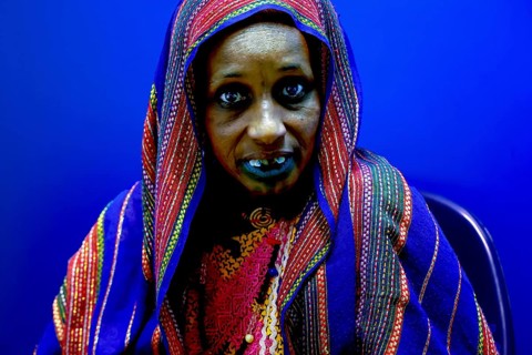 Female patient in intensive blue background and traditional clothing in hospital, Korhogo, CI, West