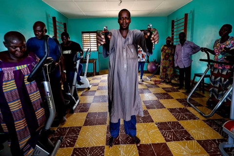 Occupational therapy at CI Korhogo with several people using training equipment in a colorful room,
