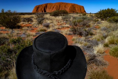 Black hat against the monumental Ayers Rock backdrop in the Australian Outback, Uluru, Northern