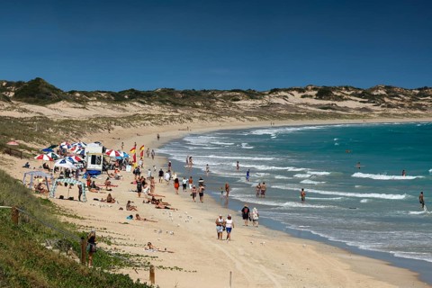 Busy cable beach with lots of visitors under blue skies, Broome, Western Australia, Australia