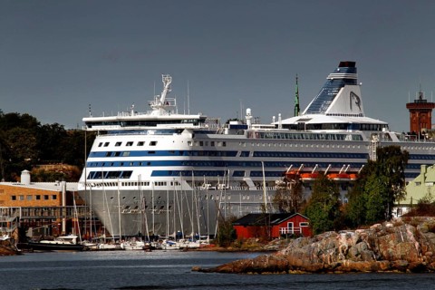 Island in Helsinki with traditional wooden house and large ferry in the background, Helsinki,