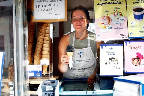 Saleswoman presents salmiac ice cream at an ice cream stand at Senaatintori, Helsinki,