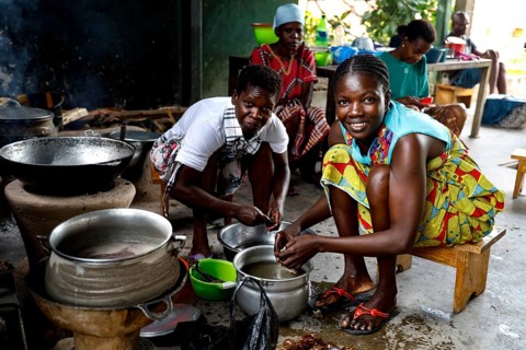 Women cooking smiling in a simple kitchen with kitchenware and pots, Bouaké, null, Côte d'Ivoire