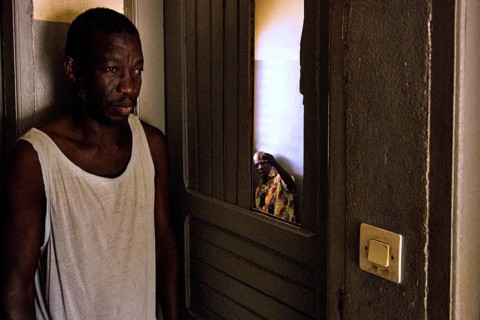 Thoughtful man standing in the shade of a door in a simple room, Bouake, null, Côte d'Ivoire