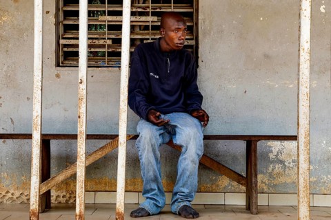 A man sits thoughtfully on a bench in a psychiatric facility in Bouaké, Bouaké, Saint Camille,