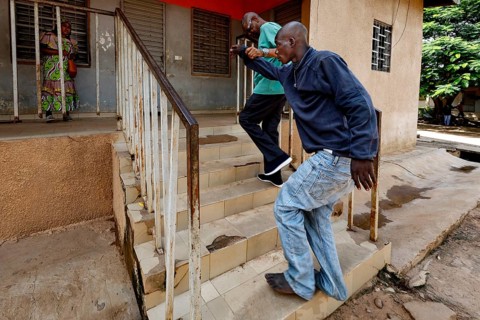 Nurse Albert helps a patient climb stairs, Bouaké, Nimbo, Côte d'Ivoire
