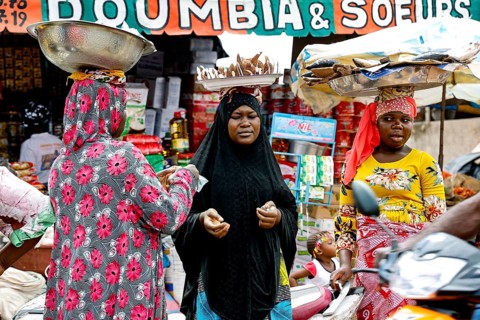 Bustling market with various goods and people in a cheerful atmosphere, CI Bouaké, Ivory Coast