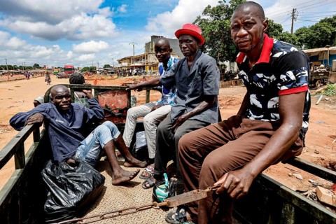 Group of men in a truck transporting a mentally ill homeless person to a psychiatric hospital,