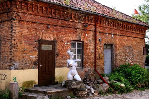 Rustic backyard with brick wall and sculpture in Uzupis, Vilnius, Vilnius County, Lithuania