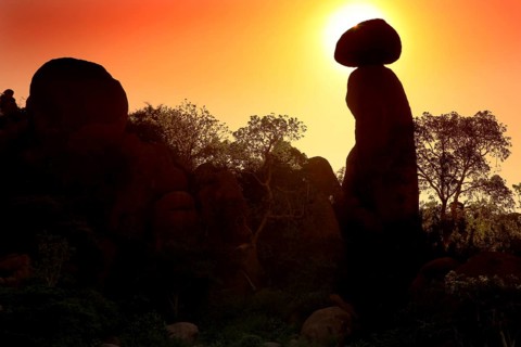 Silhouettes of rocks and trees during a spectacular sunrise in the Valley of Wonders, Babile,
