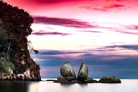 Split Apple Rock under dramatic red sky, Abel Tasman National Park, New Zealand