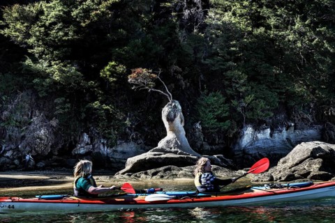 Two people kayaking in front of a rock formation on the water, Appletree Bay, Abel Tasman National
