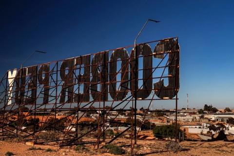 Metal structure sign in Coober Pedy shows the city name in a desert setting, Coober Pedy, South