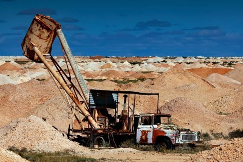 Mining machine in the opal mining area of Coober Pedy, surrounded by desert and blue sky, Coober