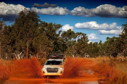 SUV crosses a muddy ford along Gibb River Road, Gibb River Road, Western Australia, Australia
