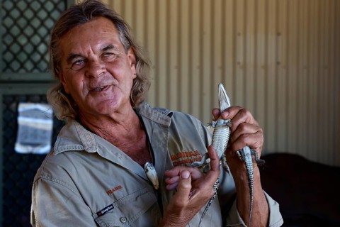 A man presents a baby crocodile in Malcolm Douglas Crocodile Park, Broome, Western Australia,