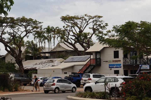 Building with parked cars and trees on Carnarvon Street, Broome, Western Australia, Australia
