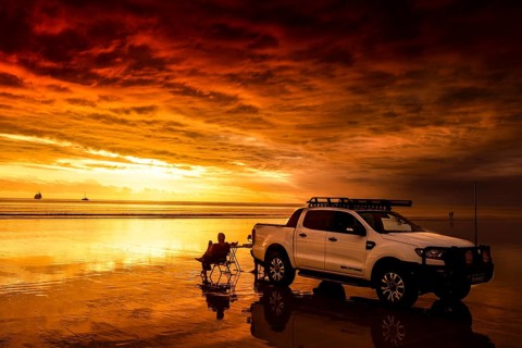 Sunset on Cable Beach with car, dog and sailboat in the distance, Broome, Western Australia,