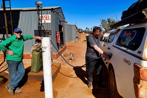 Man refuels a car at the remote Mt Dare Hotel gas station, zero