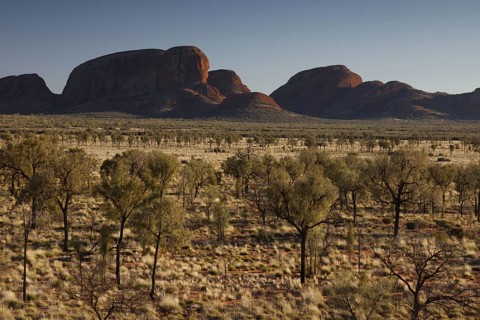 Wide desert-like landscape with distinctive rock formations in the distance, zero