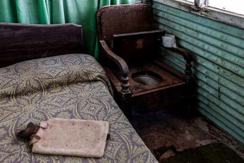 Rustic interior with bed, wooden chair and green curtains, zero