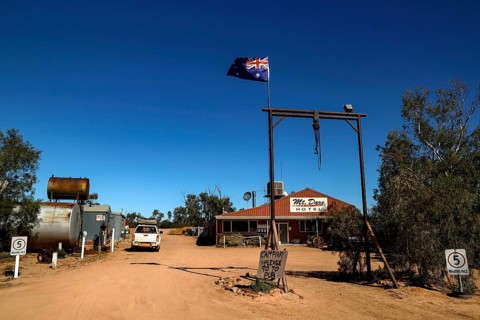 Rustic Mt Dare hotel in remote desert setting with Australian flag, zero