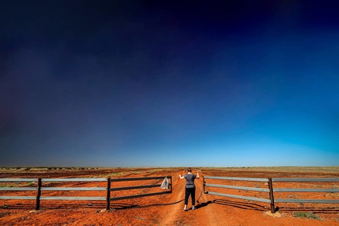 Gate on the Old Andado Track in the red sands of the desert under wide skies