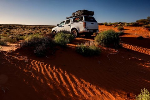 Off-road vehicle drives over sandy dunes in Simpson Desert, Simpson Desert, Australia