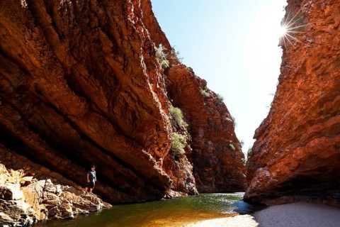 Narrow canyon of red rock with water and rays of sunlight, Simpson Gap, Northern Territory,