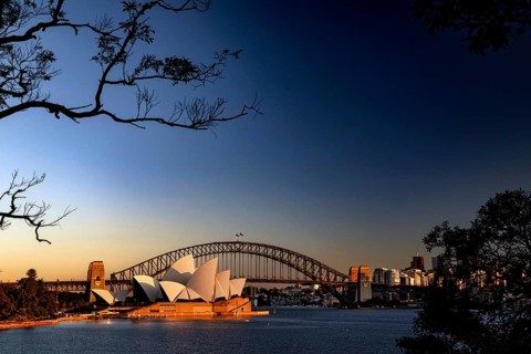 Sydney Opera House and Harbour Bridge at sunrise against blue sky, Sydney, New South Wales,